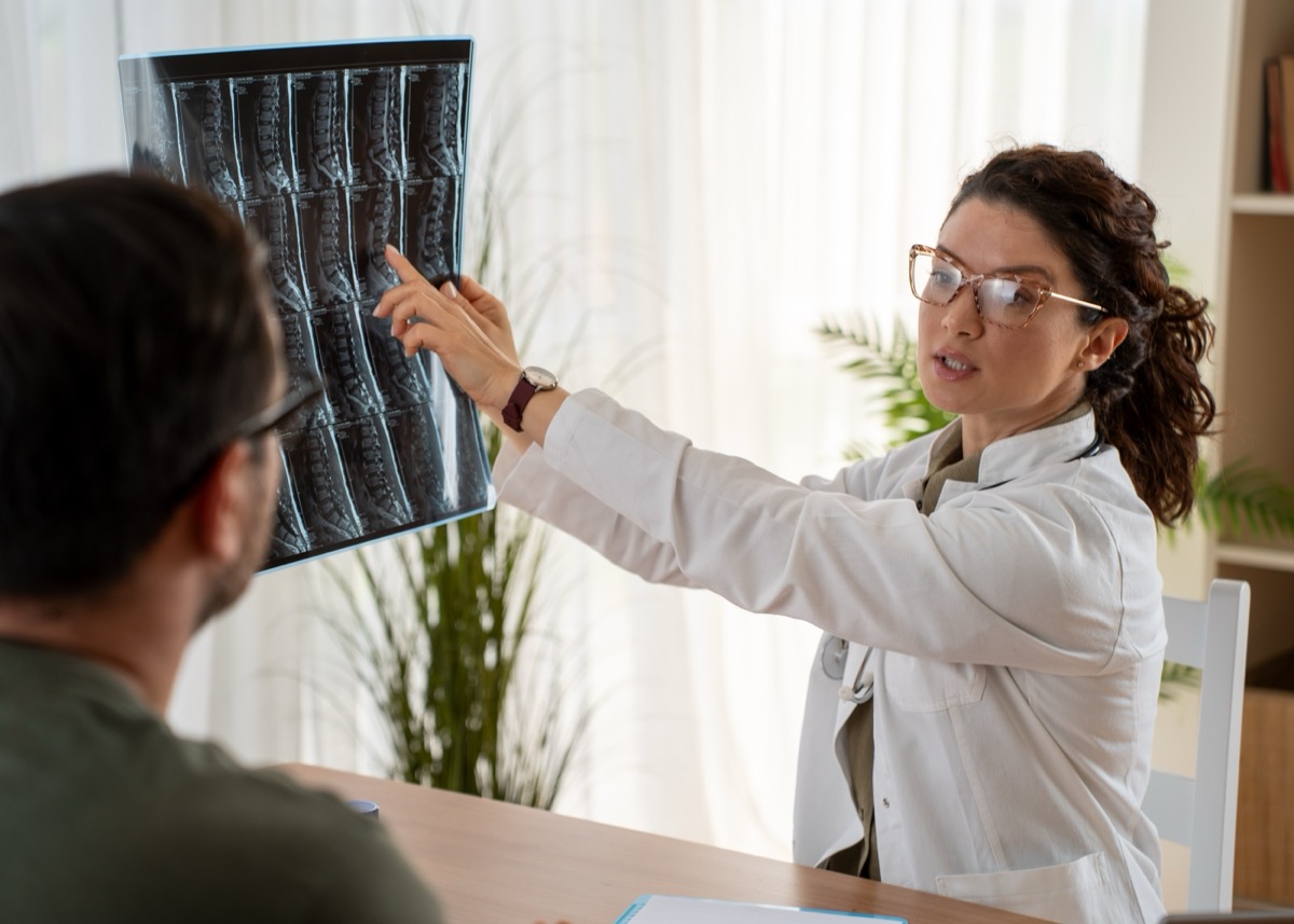 Physician reviewing a lumbar spine MRI with a patient during a consultation