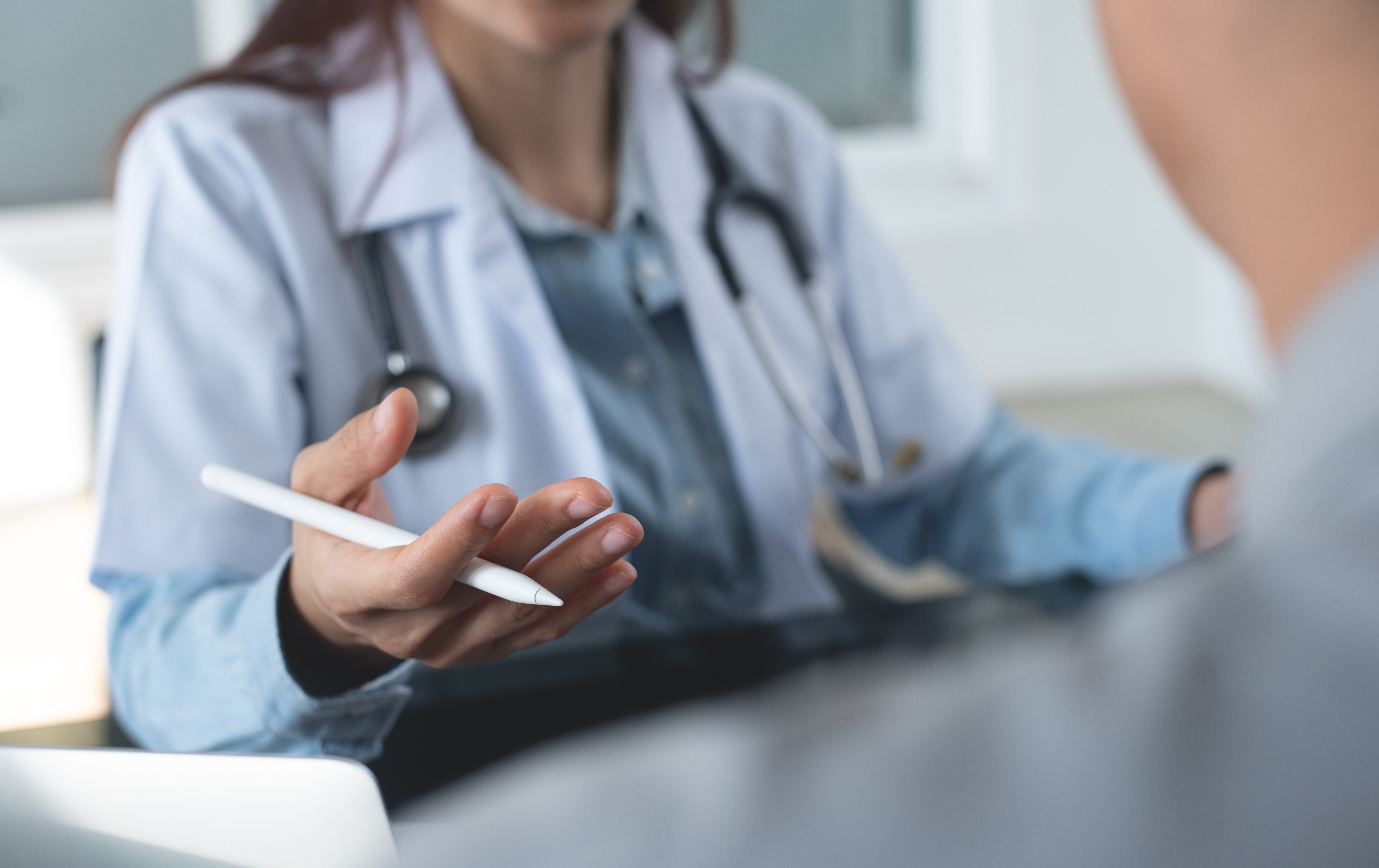 Physician discussing a treatment plan with a patient during an office consultation